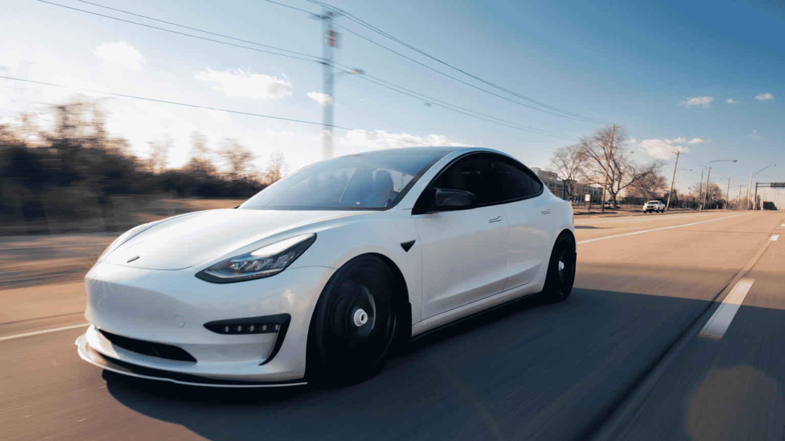 Image of white car driving on empty road