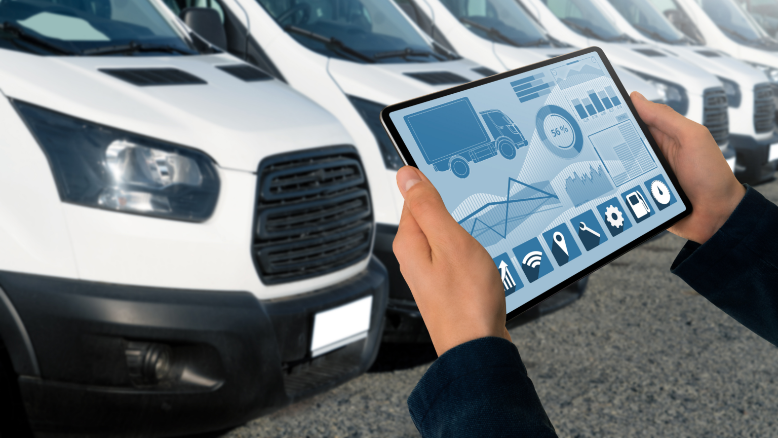 Person holding a tablet in front of white vans