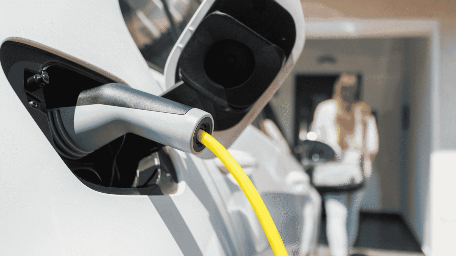 Lady standing by an electric vehicle that is charging